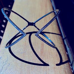 A beautiful silver bracelet with crystals on the outside of the bracelet.